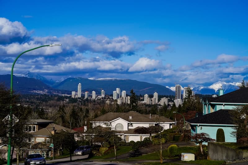 Suburban homes with city skyline and mountains in the background